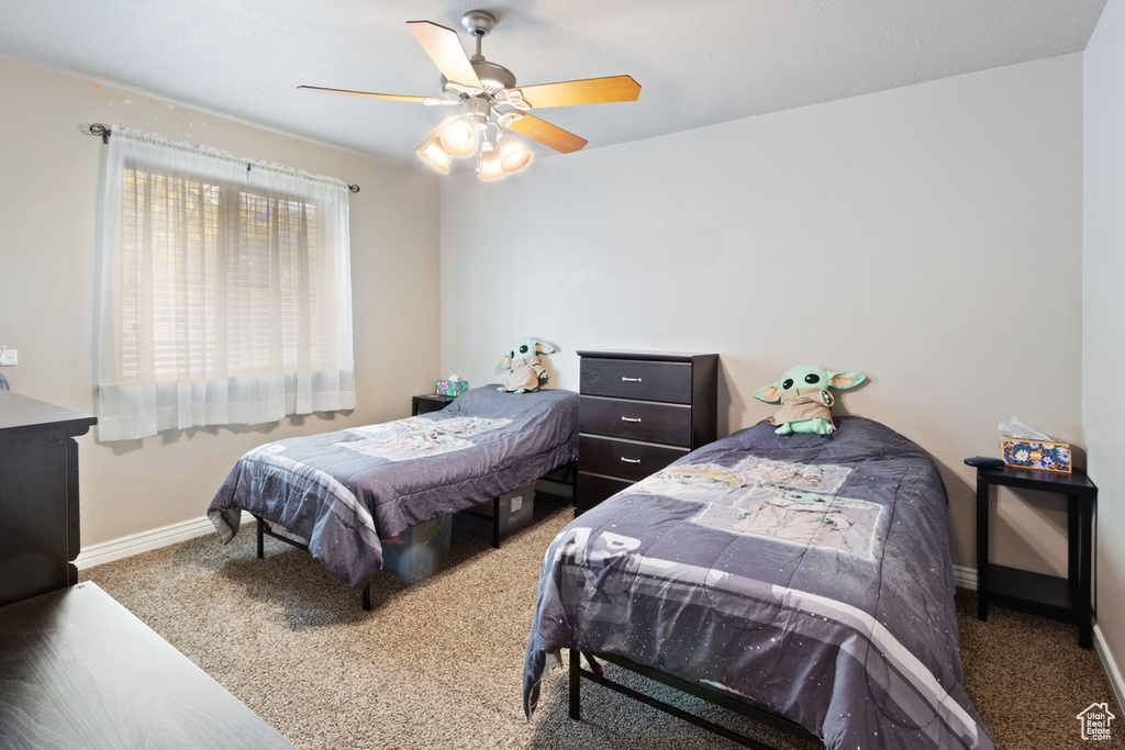 Bedroom featuring carpet floors, baseboards, and a ceiling fan