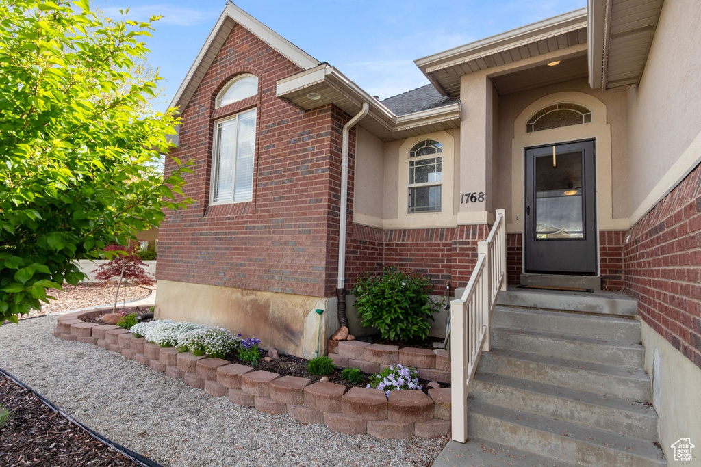 Doorway to property with brick siding and stucco siding