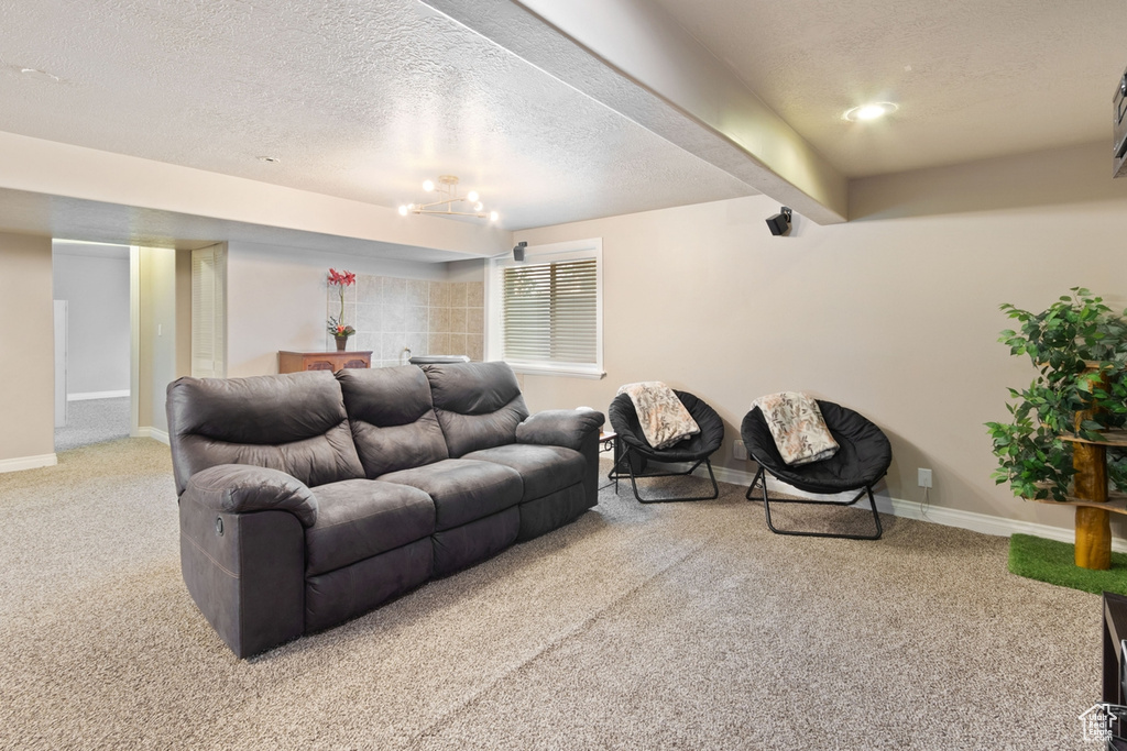 Carpeted living room featuring a textured ceiling and baseboards