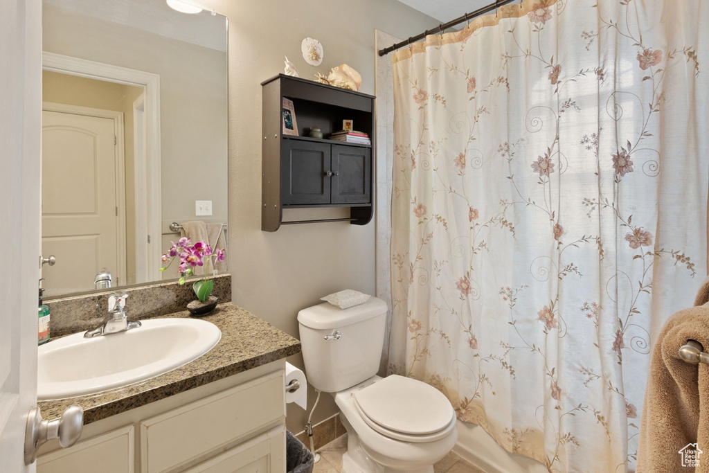 Bathroom with vanity, toilet, and a shower with curtain