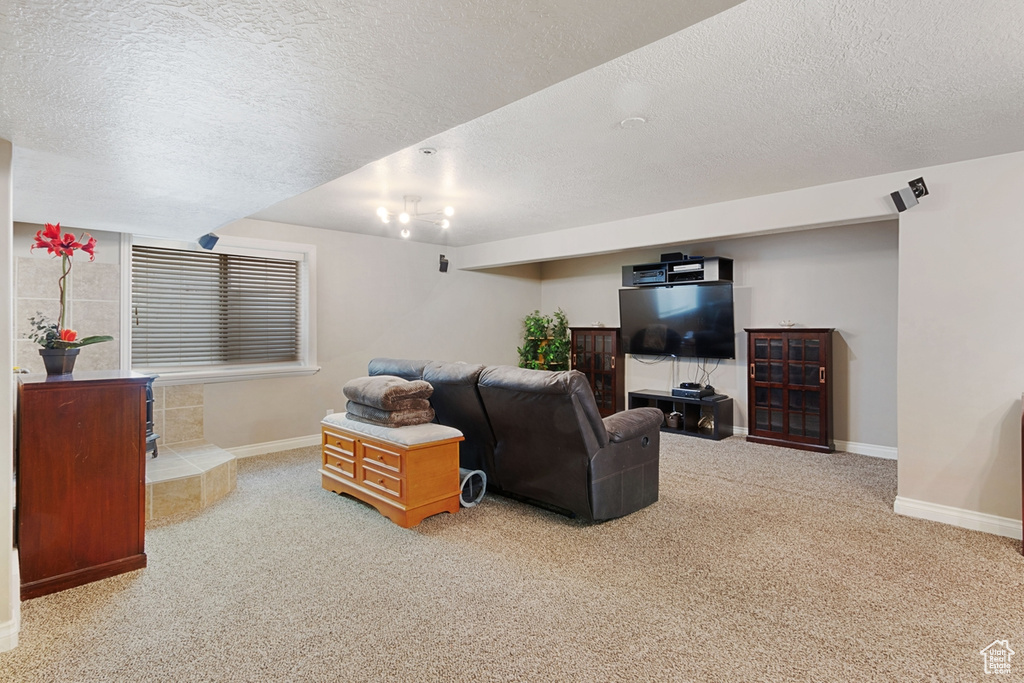 Carpeted living area featuring a textured ceiling and baseboards