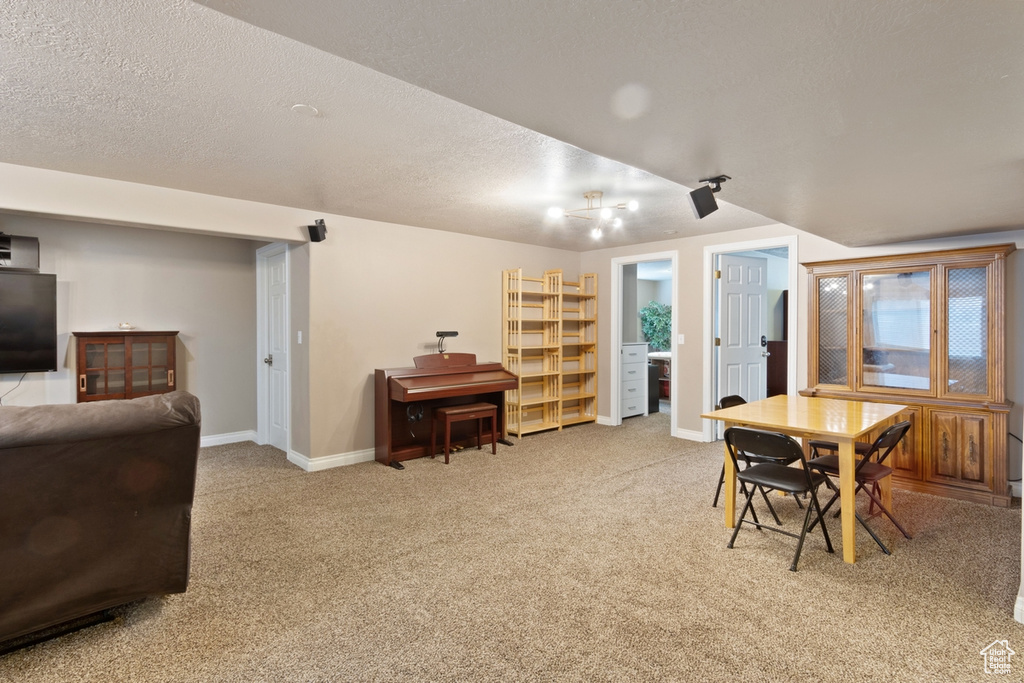 Dining space featuring baseboards, carpet floors, and a textured ceiling