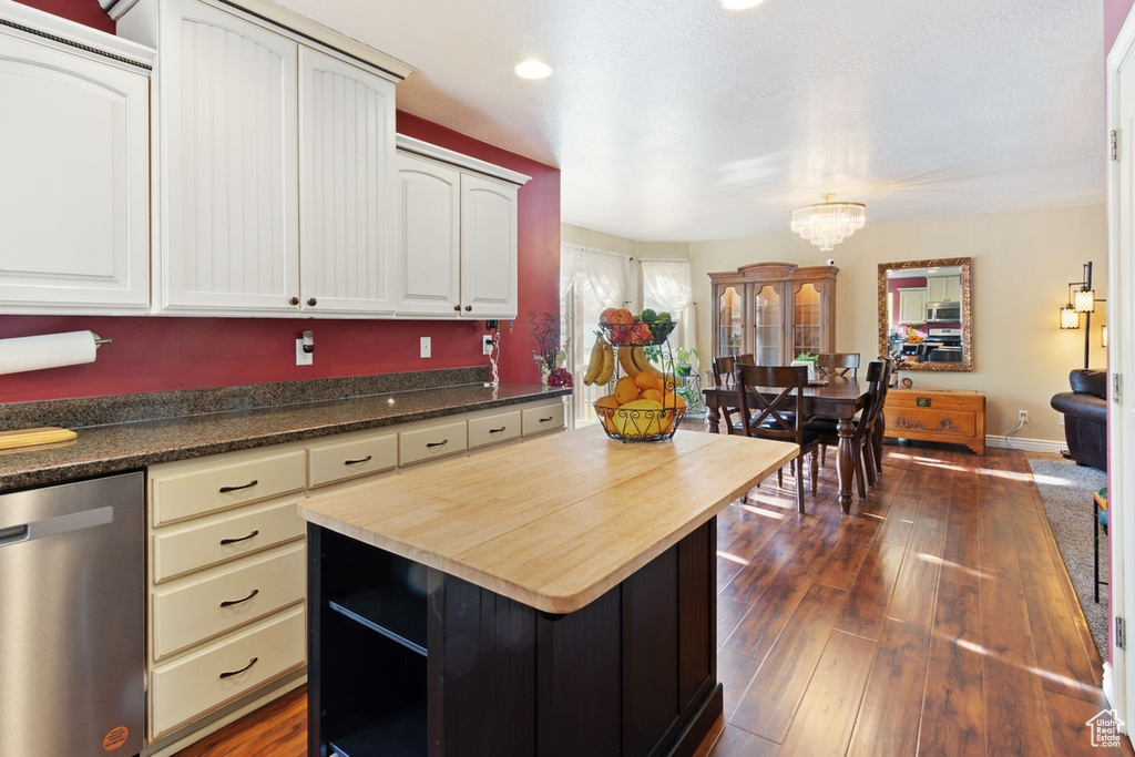 Kitchen featuring stainless steel appliances, dark wood-style floors, wood counters, a chandelier, and a kitchen island