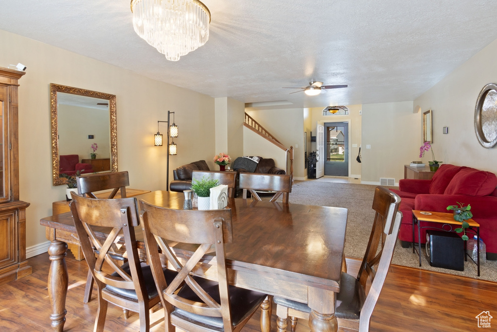 Dining space featuring stairway, a ceiling fan, baseboards, and wood finished floors