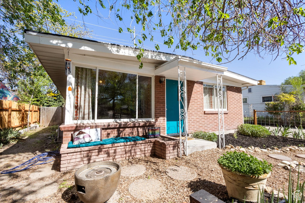 Rear view of house featuring fence and brick siding