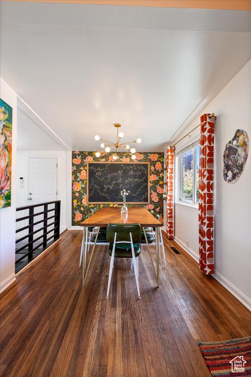 Dining room with baseboards, an inviting chandelier, visible vents, and wood finished floors
