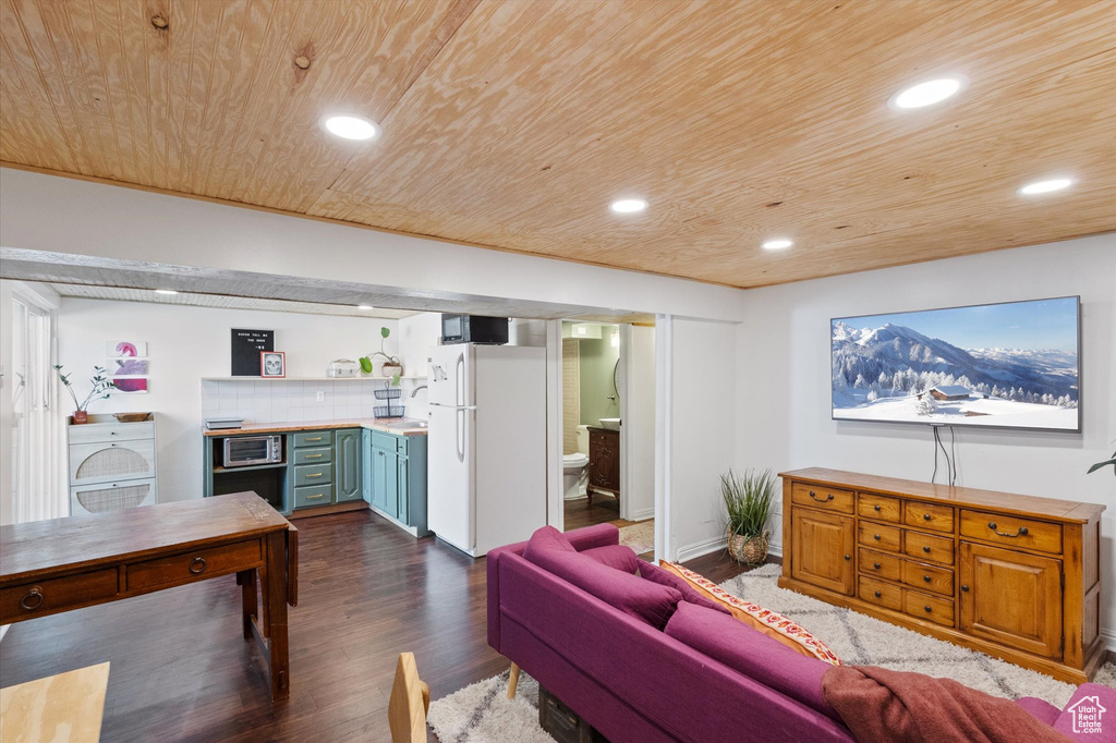 Living area with washer / clothes dryer, recessed lighting, dark wood-style flooring, wood ceiling, and indoor bar