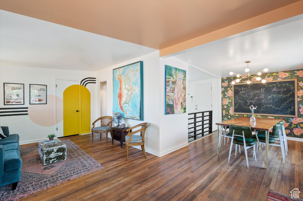 Living room featuring an inviting chandelier, baseboards, and wood finished floors