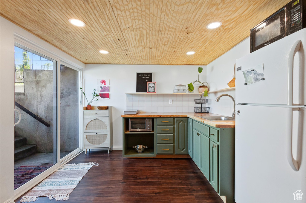Bar featuring freestanding refrigerator, dark wood-style flooring, wood ceiling, and a sink