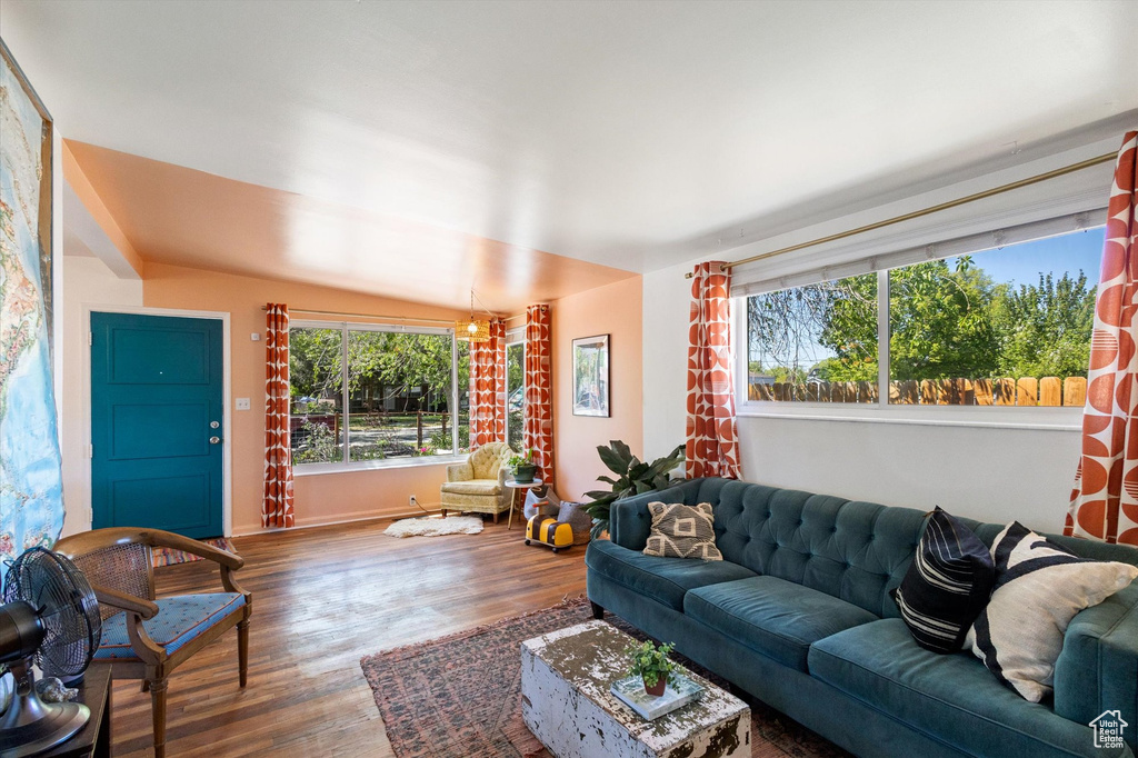 Living area featuring lofted ceiling, baseboards, and wood finished floors