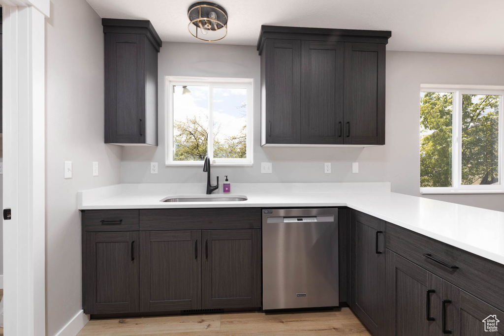 Kitchen with dishwasher, a sink, healthy amount of natural light, and light countertops