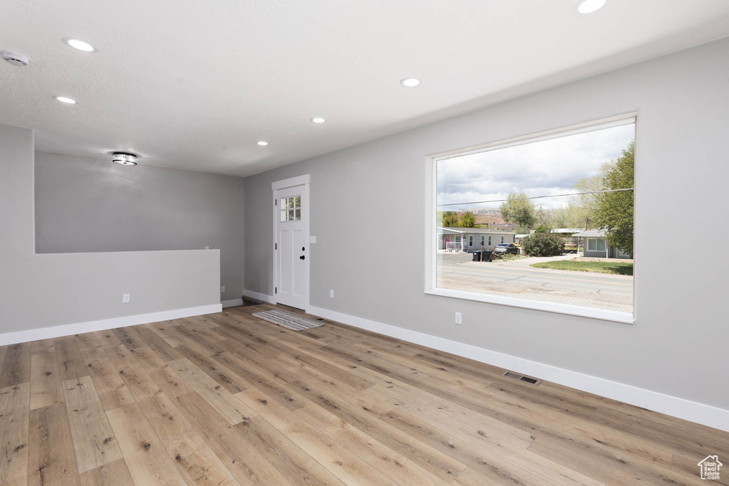 Unfurnished room featuring plenty of natural light, recessed lighting, baseboards, and hardwood / wood-style flooring
