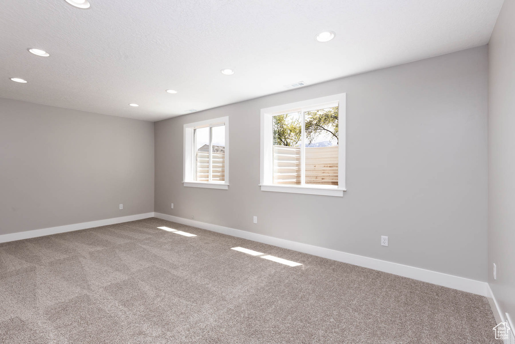 Spare room with carpet flooring, baseboards, and recessed lighting