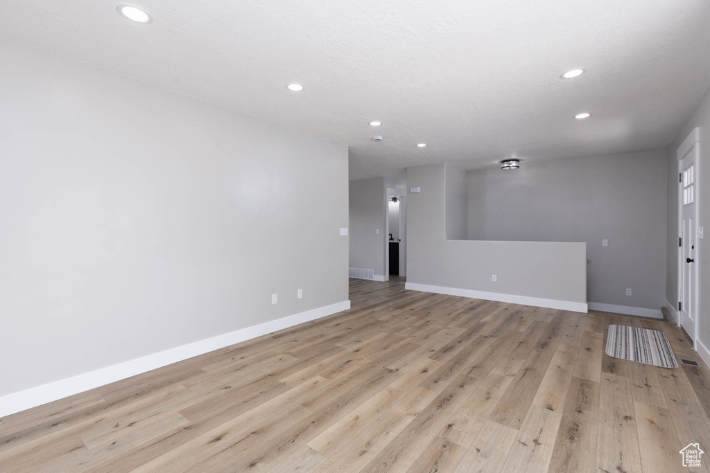 Spare room featuring recessed lighting, baseboards, and light wood-type flooring