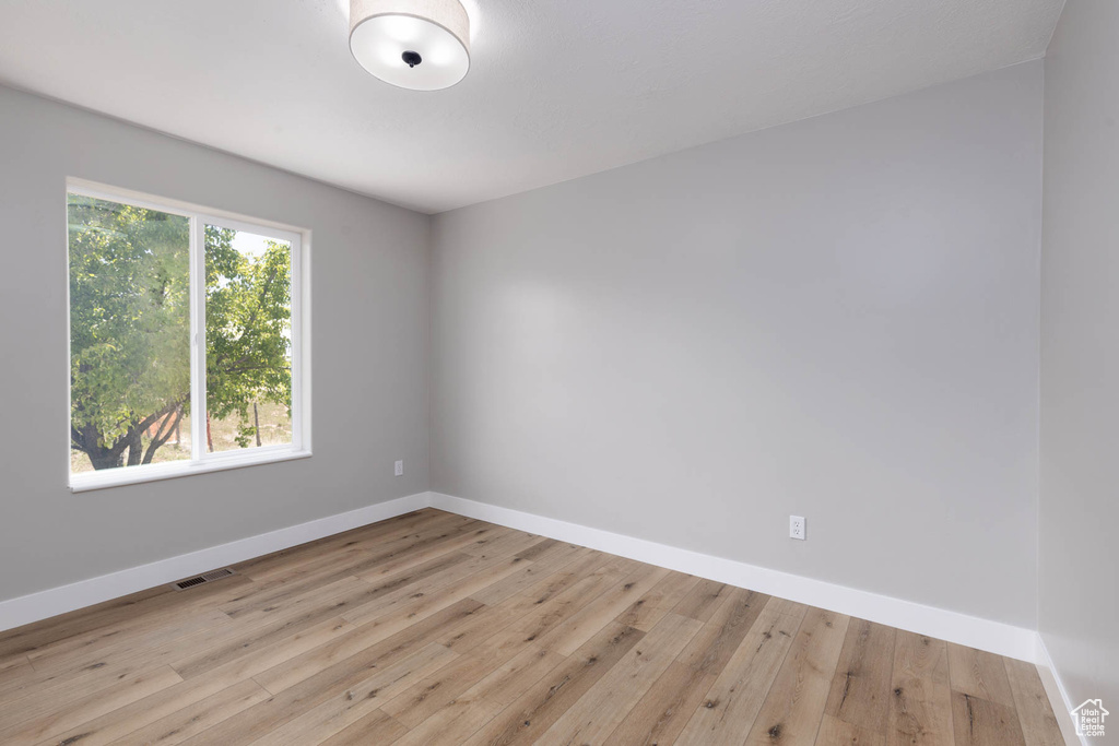 Unfurnished room with baseboards and wood finished floors