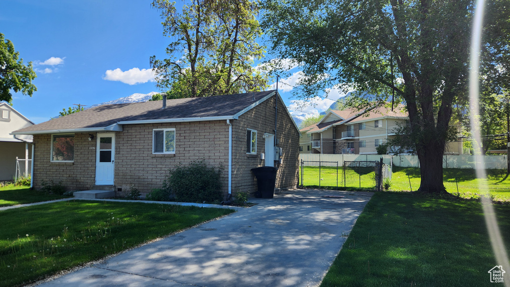 View of front of home with concrete driveway, entry steps, and a shingled roof