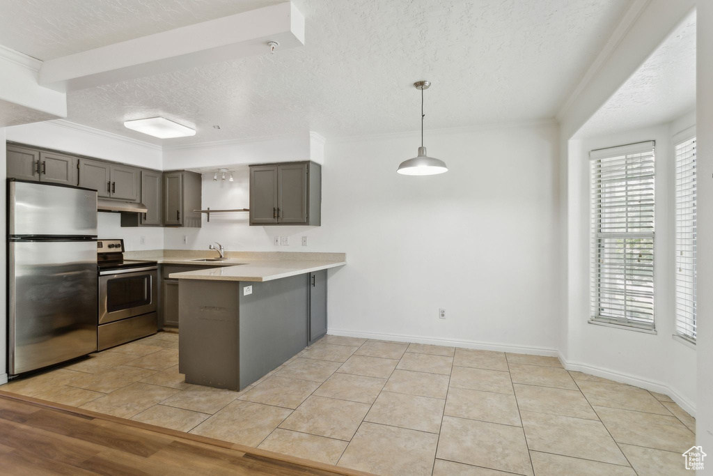 Kitchen with appliances with stainless steel finishes, under cabinet range hood, a peninsula, a textured ceiling, and gray cabinets