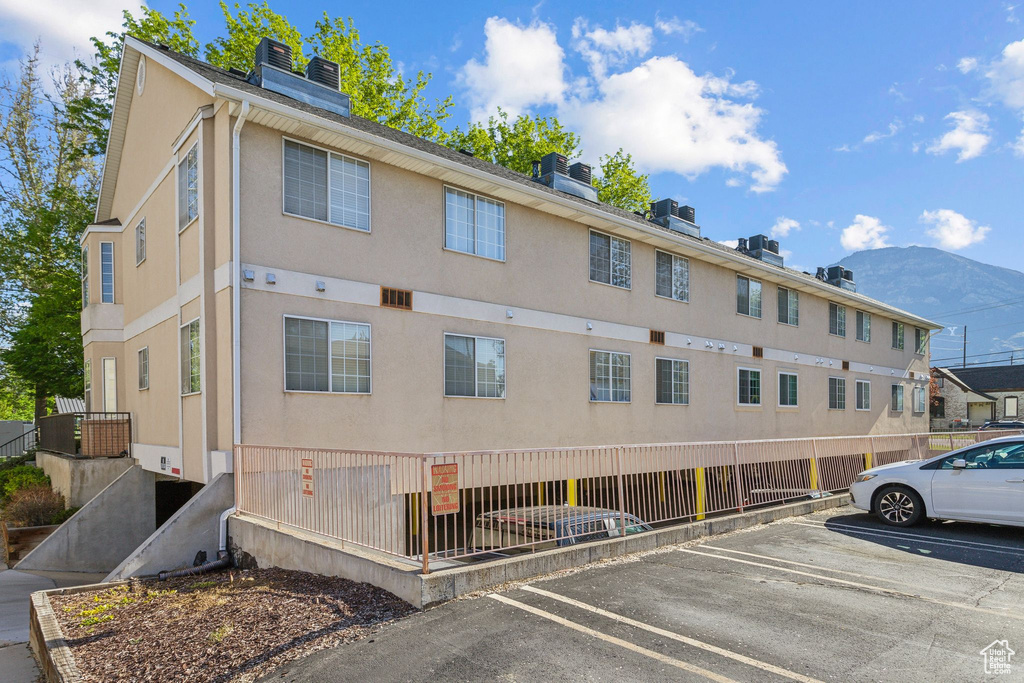 View of building exterior featuring uncovered parking and a mountain view