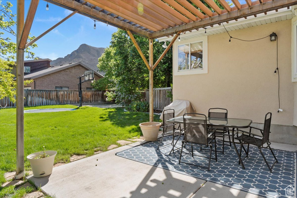 View of patio with a mountain view, a pergola, and outdoor dining space