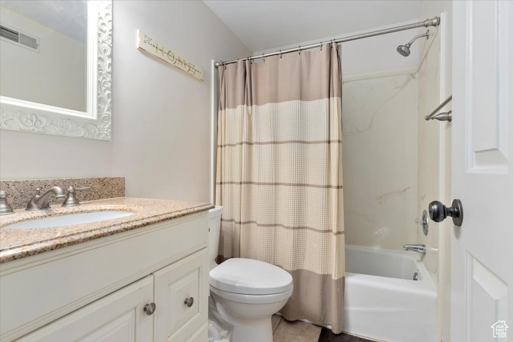 Full bath featuring toilet, vanity, and shower / bath combination with curtain