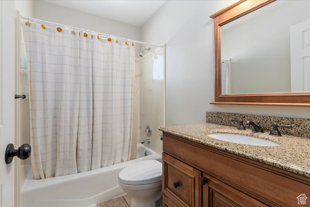 Full bath with shower / bath combo with shower curtain, toilet, and vanity