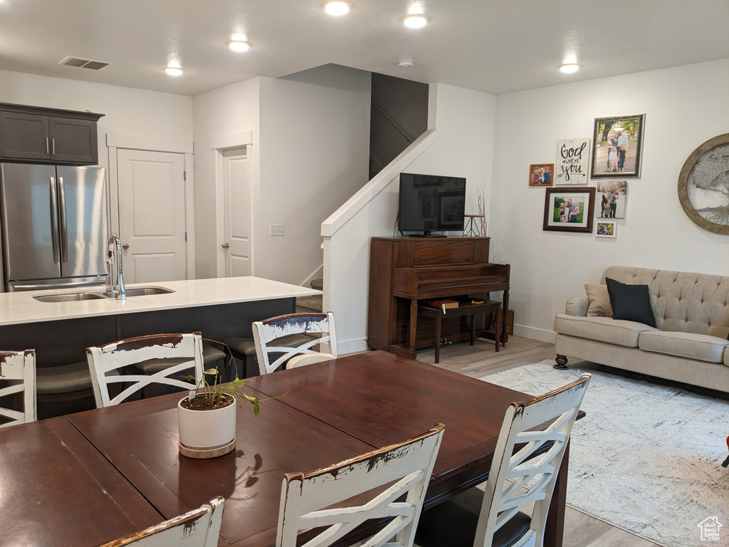 Dining room featuring visible vents, stairs, baseboards, and light wood-type flooring