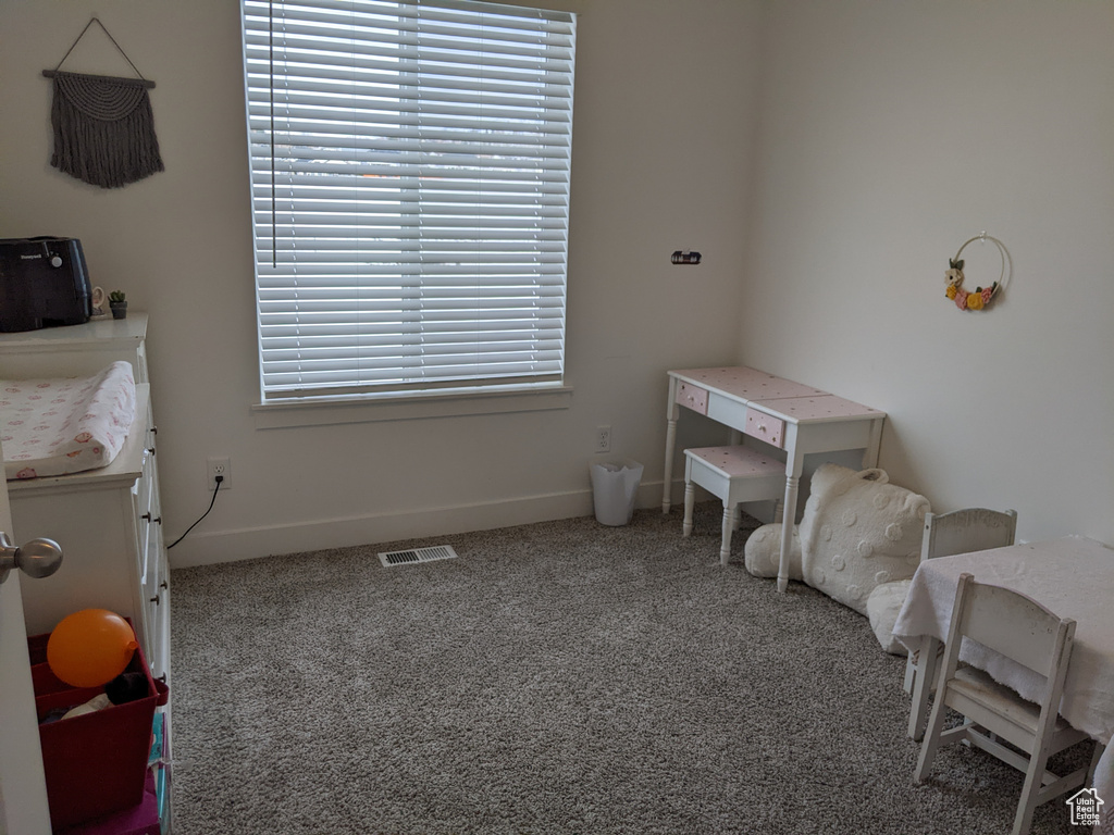 Carpeted bedroom featuring baseboards and visible vents