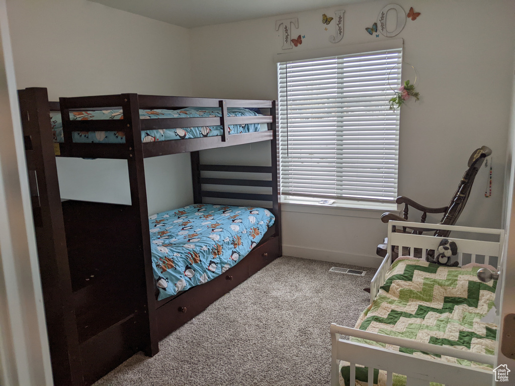 Carpeted bedroom with baseboards and visible vents