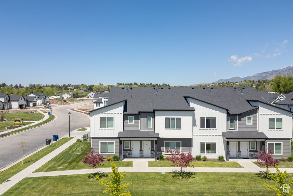 View of front facade featuring board and batten siding, a residential view, a shingled roof, and a mountain view