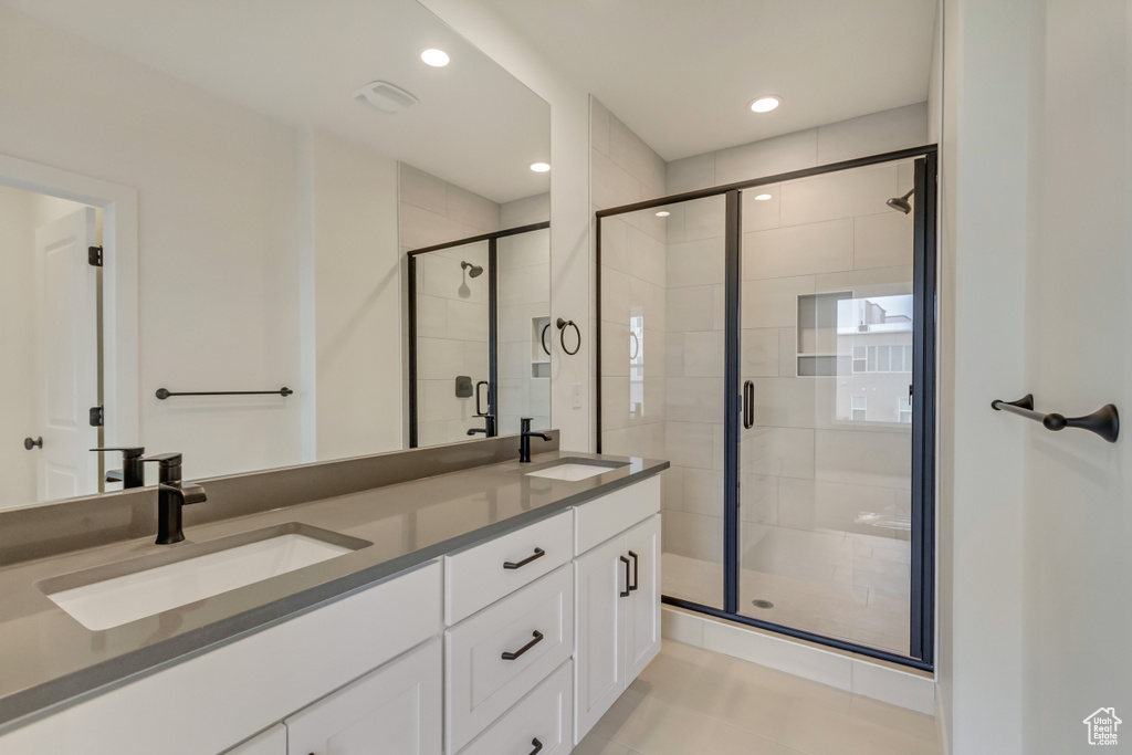 Full bathroom with a shower stall, double vanity, recessed lighting, and tile patterned floors