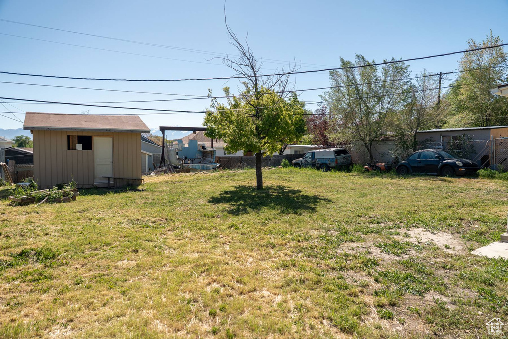 View of yard featuring an outdoor structure and fence