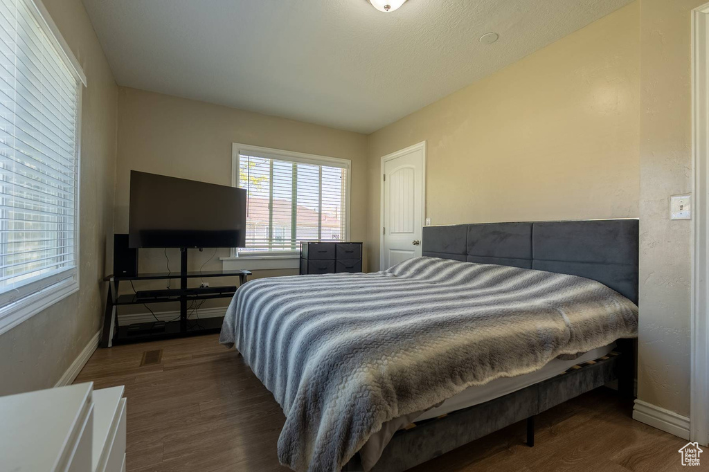 Bedroom with wood finished floors and baseboards