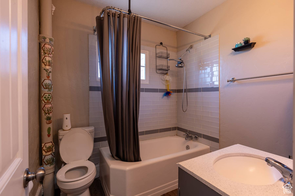 Bathroom featuring vanity, toilet, and shower / bath combo