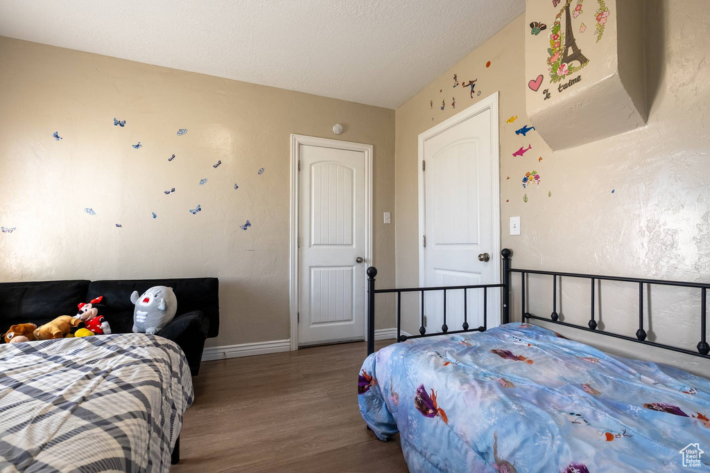 Bedroom with wood finished floors and baseboards