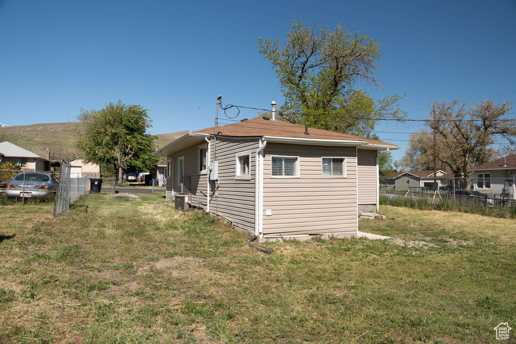 Back of house featuring a yard and fence