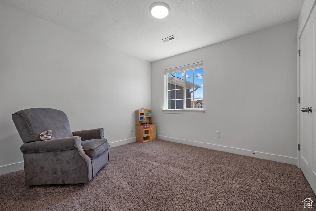 Living area featuring carpet floors and baseboards