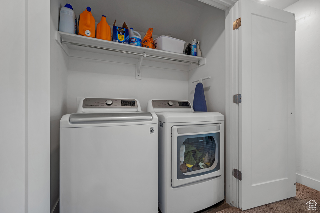 Laundry area featuring washer and clothes dryer and carpet flooring
