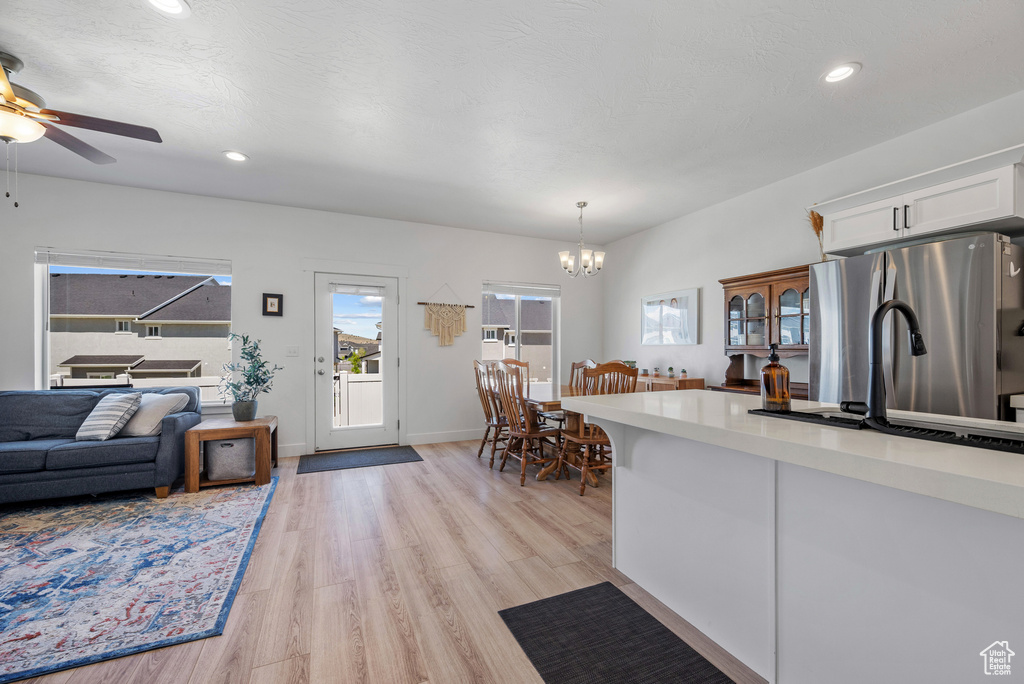 Kitchen featuring white cabinets, a chandelier, light wood finished floors, plenty of natural light, and recessed lighting