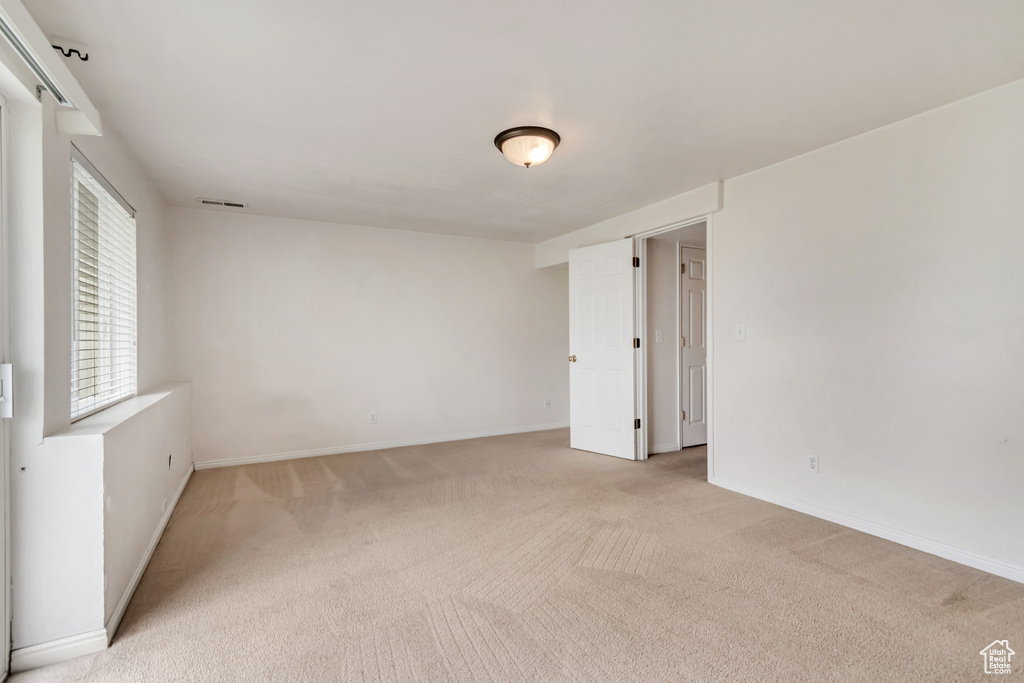 Empty room with light carpet and baseboards