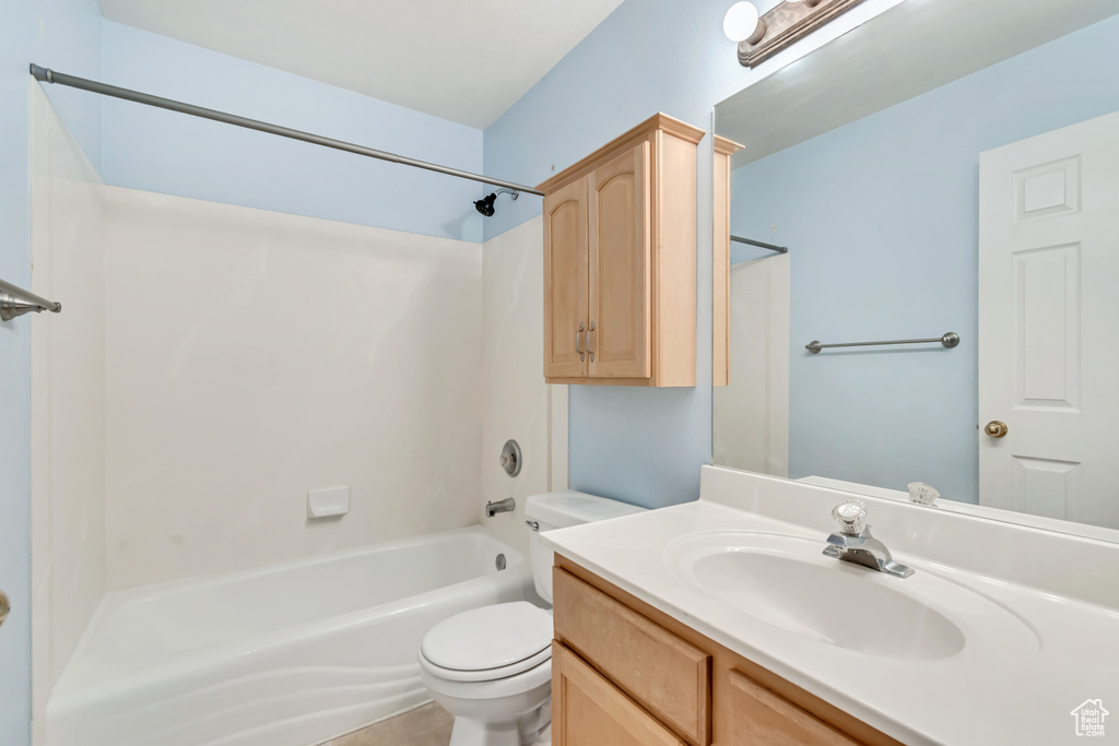 Bathroom featuring toilet, vanity, and washtub / shower combination