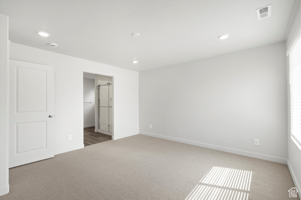 Unfurnished bedroom with carpet floors, recessed lighting, and multiple windows