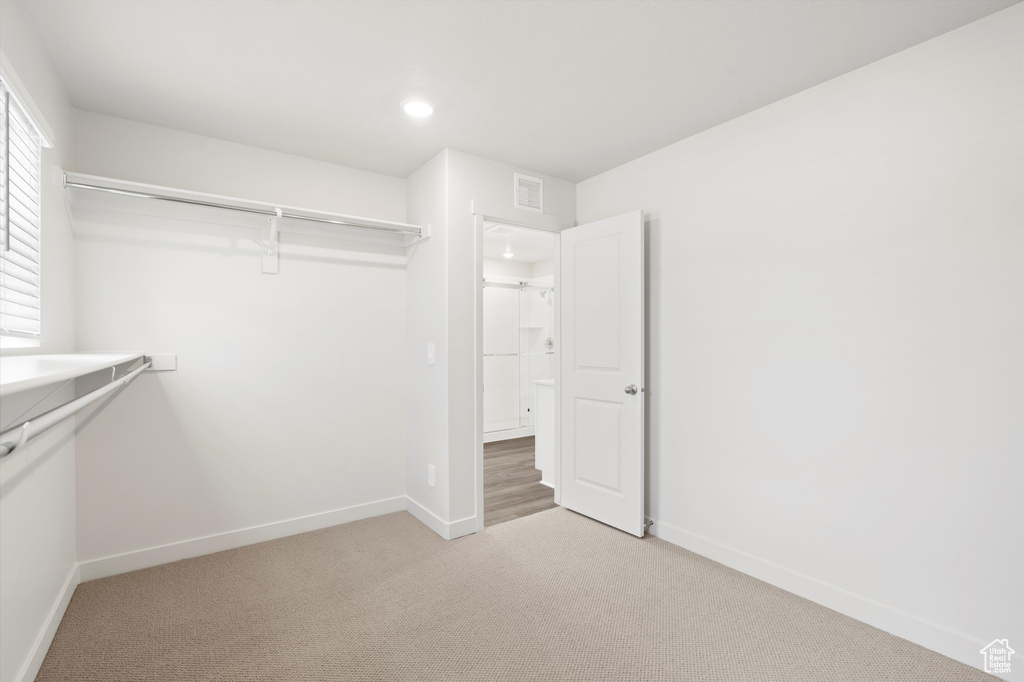 Spacious closet with light colored carpet