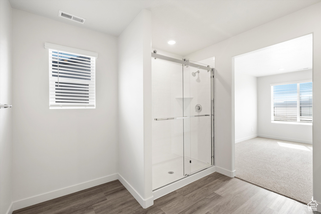 Full bath featuring a stall shower, wood finished floors, and recessed lighting