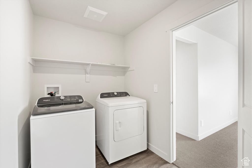 Washroom featuring independent washer and dryer and baseboards