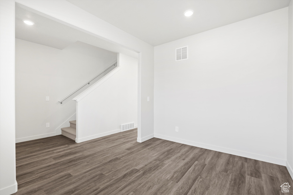 Empty room featuring wood finished floors, stairs, and recessed lighting