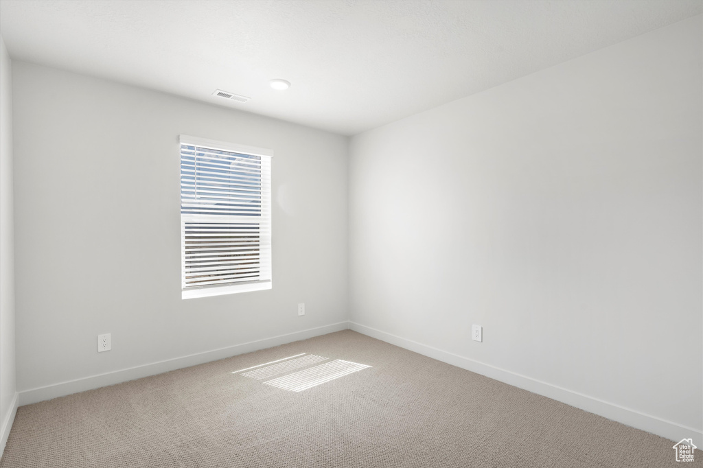 Unfurnished room featuring light colored carpet and baseboards