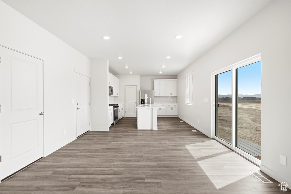 Unfurnished living room with recessed lighting and light wood-type flooring