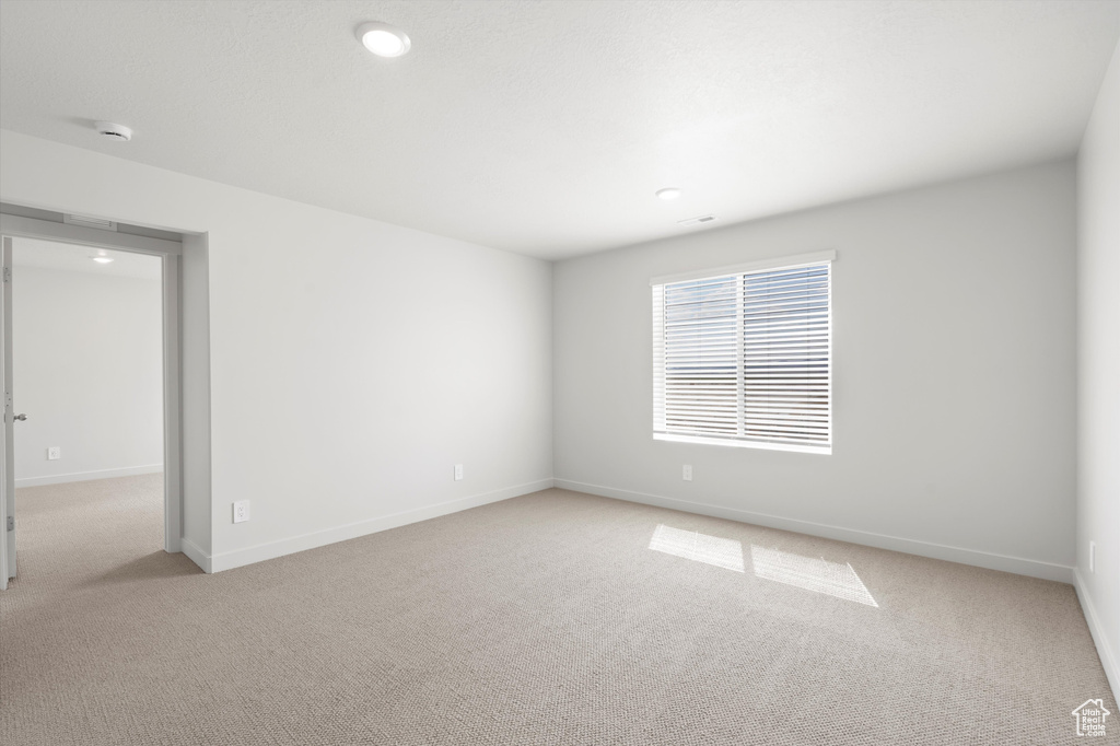 Carpeted empty room with recessed lighting