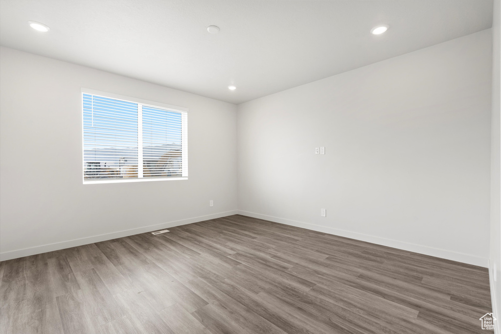 Empty room with wood finished floors and recessed lighting