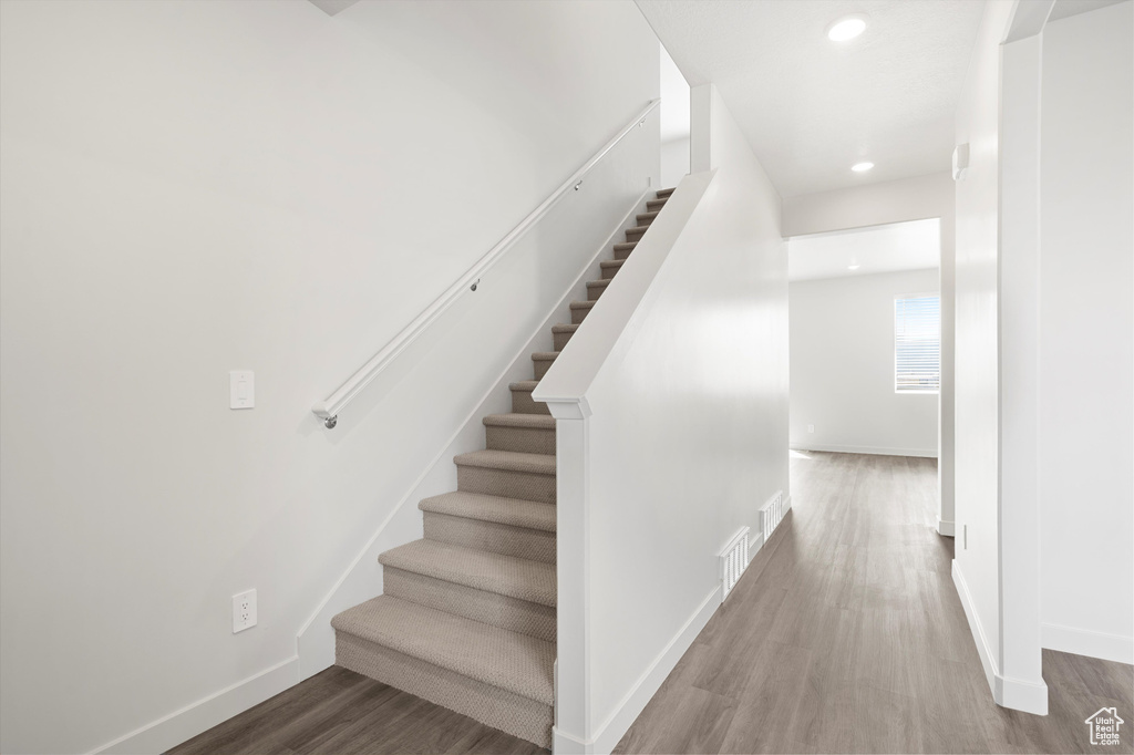 Stairway featuring recessed lighting and wood finished floors